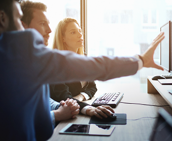 Three people looking at computer screen