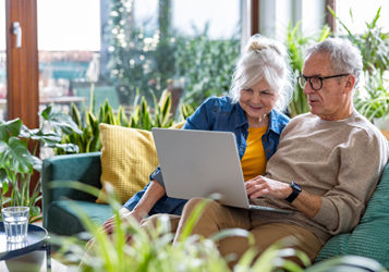 Couple sitting looking at laptop